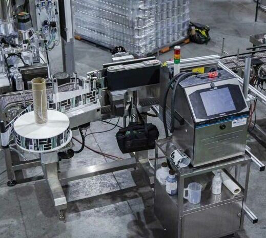 can labeling machine with a pallet full of canned beer behind it.